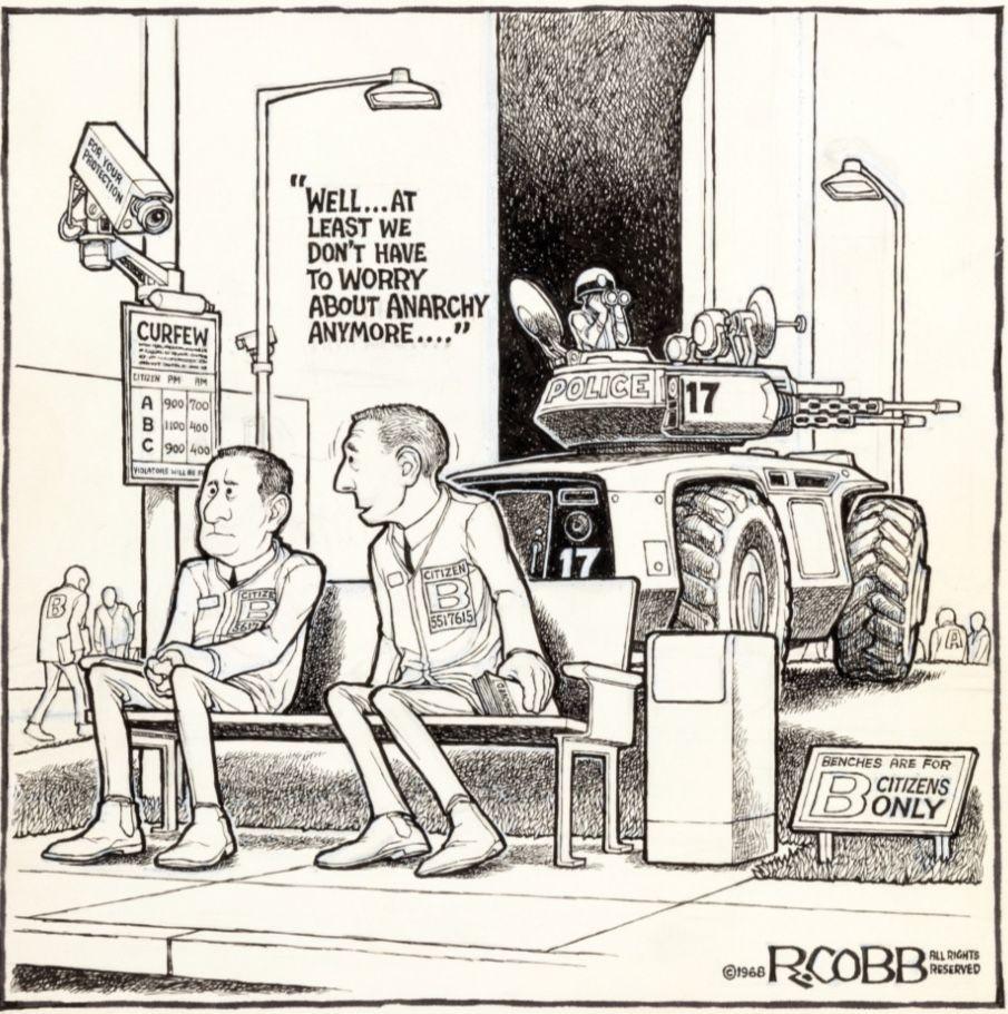 Una vignetta di Ron Cobb del 1968. Due uomini in uniformi "Cittadino B" abbinate sono seduti su una panchina. Un cartello lì vicino recita: "Le panchine sono riservate solo ai cittadini di categoria B" Le telecamere di sicurezza sono dotate di segnaletica che indica gli orari di coprifuoco per i cittadini A, B e C. Sullo sfondo rotola un carro armato della polizia pesantemente corazzato. Uno degli uomini dice: "Beh... almeno non dobbiamo più preoccuparci dell'anarchia..."

A 1968 Ron Cobb cartoon. Two men in matching "Citizen B" uniforms are sitting on a bench. A nearby sign says "Benches are for B citizens only." Security cameras include signage designating curfew hours for A, B, and C citizens. A heavily armored police tank rolls by in the background. One of the men is saying, "Well... at least we don't have to worry about anarchy anymore..."